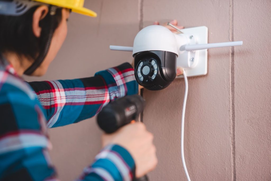 person drilling cctv onto a wall